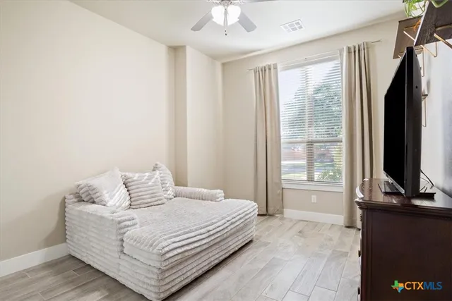 a bedroom with a bed table and flat screen tv