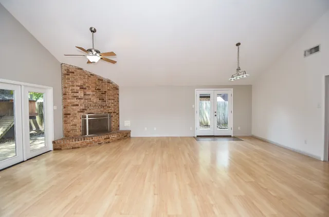 a view of a livingroom with a fireplace a chandelier and wooden floor