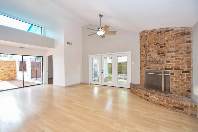 a view of an empty room with a fireplace and a window