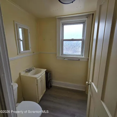 a bathroom with a sink toilet and window