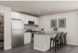 a kitchen with kitchen island a dining table chairs stainless steel appliances and cabinets