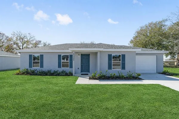 a front view of a house with a garden and yard