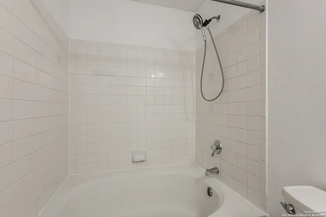 a bathroom with a bath tub with a shower