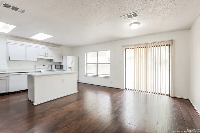 a kitchen with wooden floors white cabinets and wooden floors
