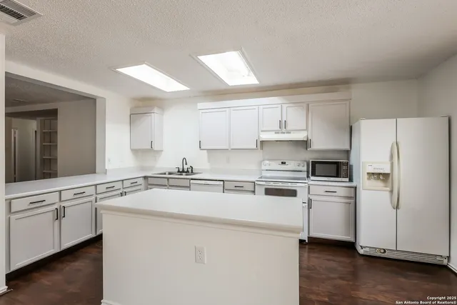 a kitchen with stainless steel appliances white cabinets and a refrigerator