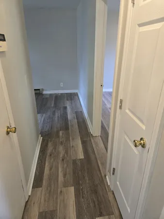 a view of a hallway with wooden floor and staircase