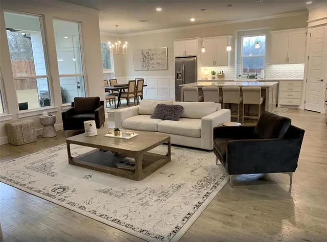 a living room with furniture wooden floor and a large window