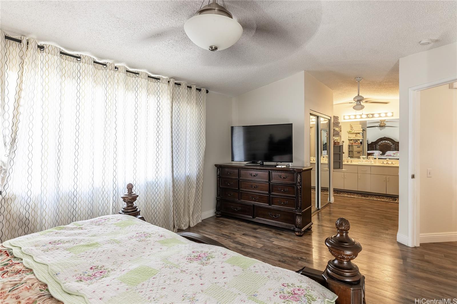 91-957 Laaulu Street, Unit 40F Ewa Beach, HI 96706 - Photo 12 of 22 a bedroom with a bed and a flat screen tv