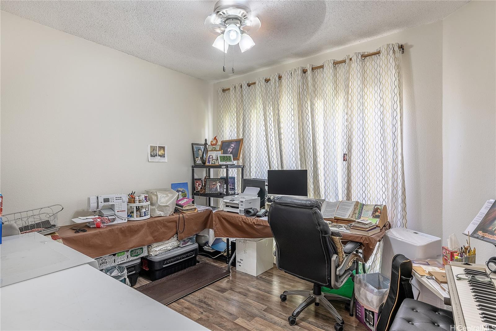 91-957 Laaulu Street, Unit 40F Ewa Beach, HI 96706 - Photo 14 of 22 a bedroom with a bed a desk and chair
