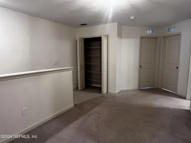 an empty room with a window and a ceiling fan