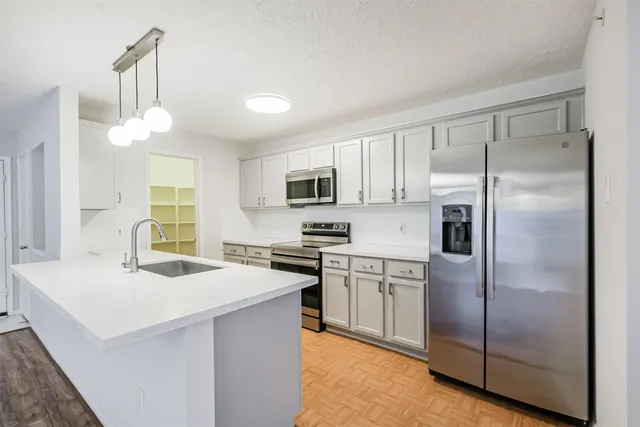 a kitchen with kitchen island a counter top space stainless steel appliances and cabinets