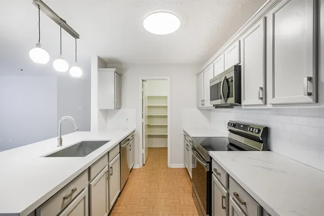 a kitchen that has a sink and a stove in it