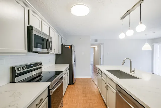 a kitchen with stainless steel appliances a stove sink microwave and cabinets