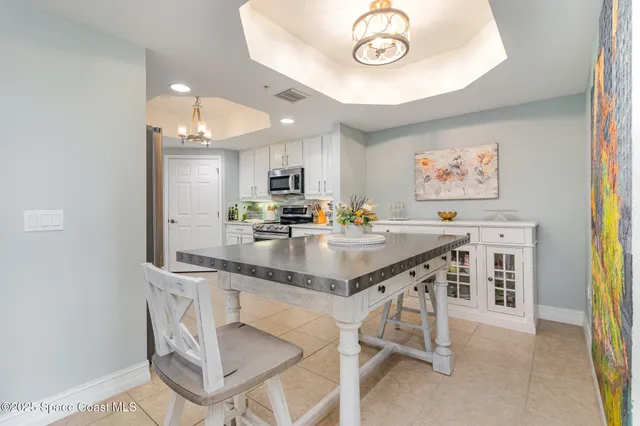 a kitchen with stainless steel appliances a table and chairs in it