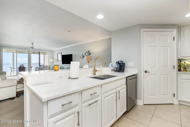 a view of living room with granite countertop white cabinets and white appliances