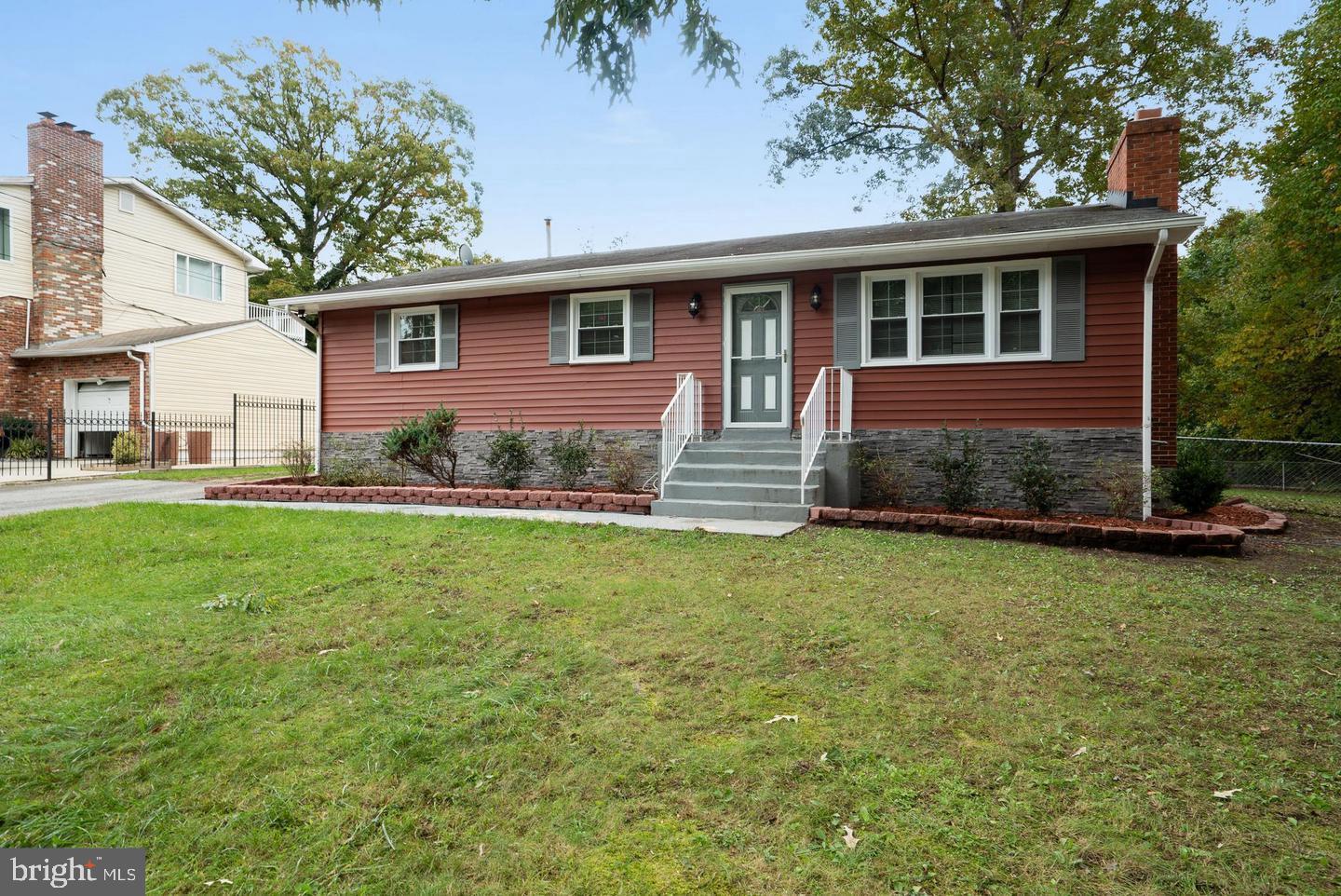 a front view of house with yard and trees in the background
