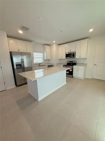 a large kitchen with a large counter top appliances and cabinets