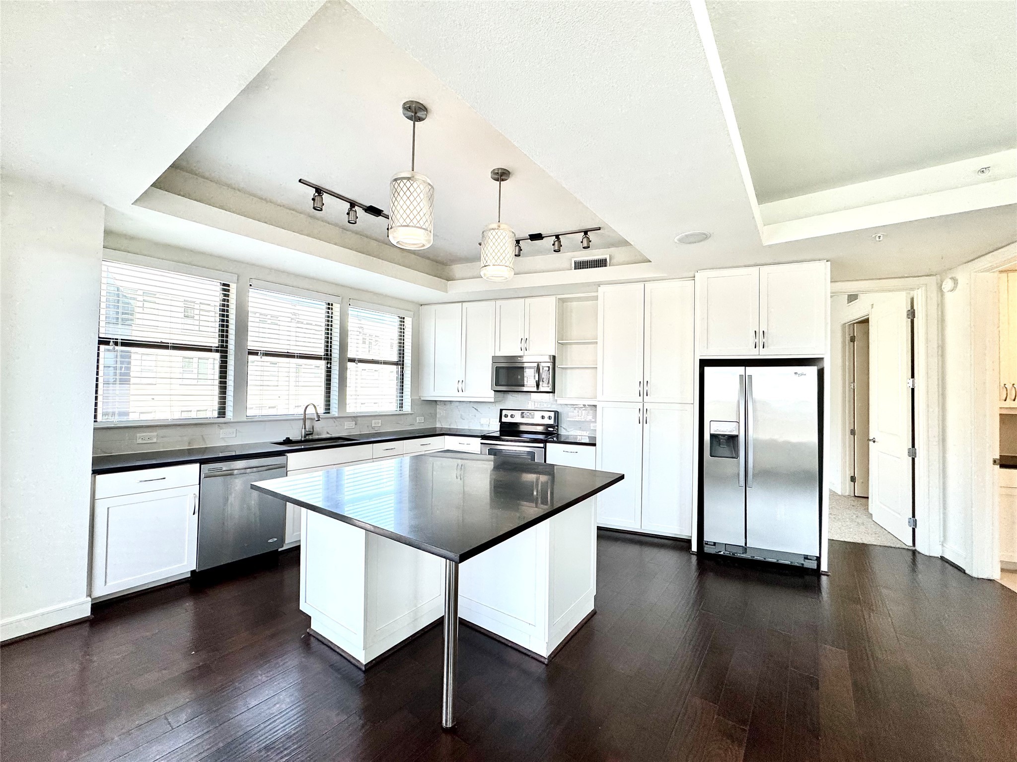 2303 Mid Lane, Unit 228 Houston, TX 77027 - Photo 3 of 30 a kitchen with stainless steel appliances granite countertop a refrigerator a sink dishwasher a stove and white countertops with wooden floor