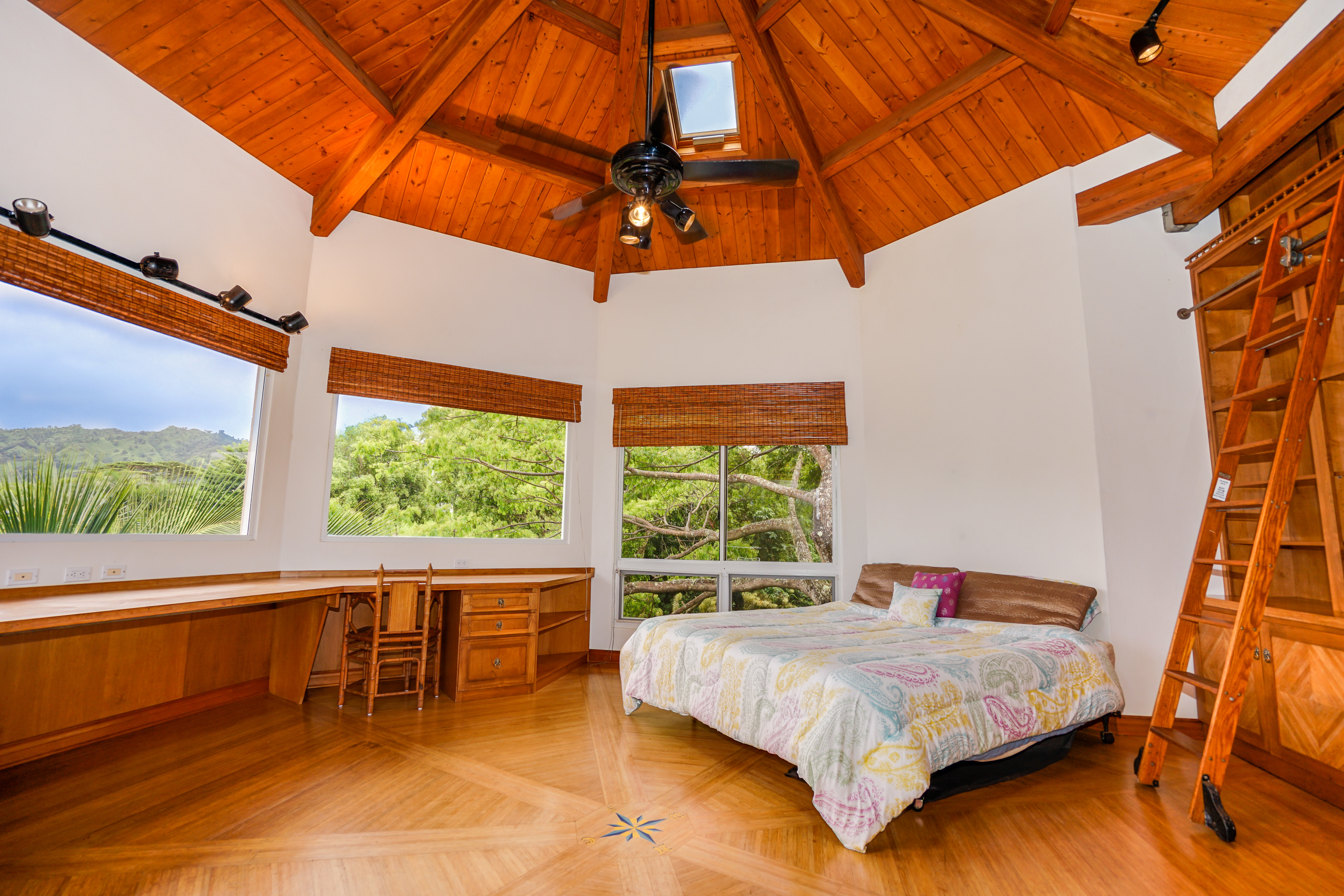 4700 Kapuna Road Kilauea, HI 96754 - Photo 10 of 17 a bed sitting in a bedroom next to a blue chair