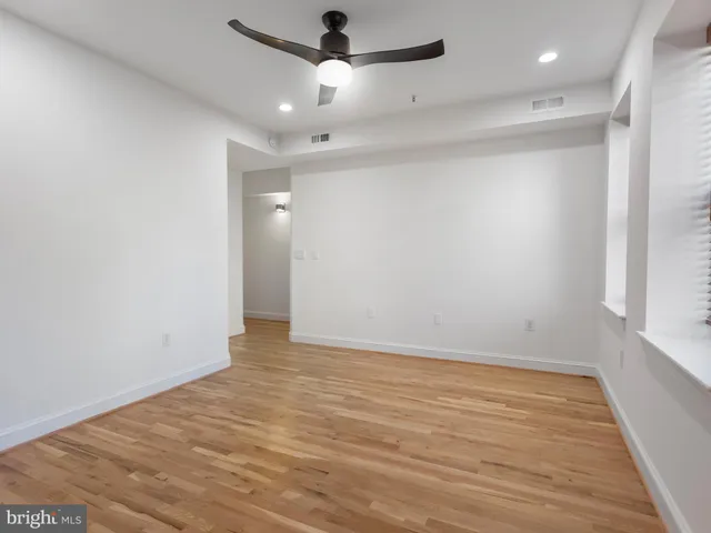 an empty room with wooden floor a ceiling fan and closet