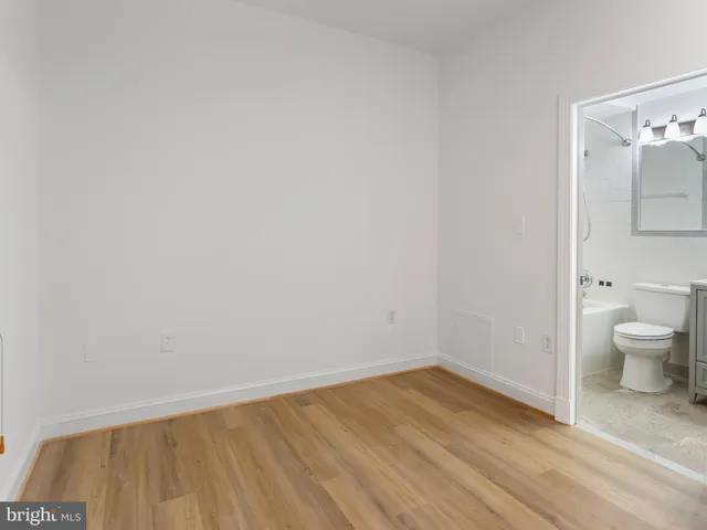 a view of a room with wooden floor and toilet
