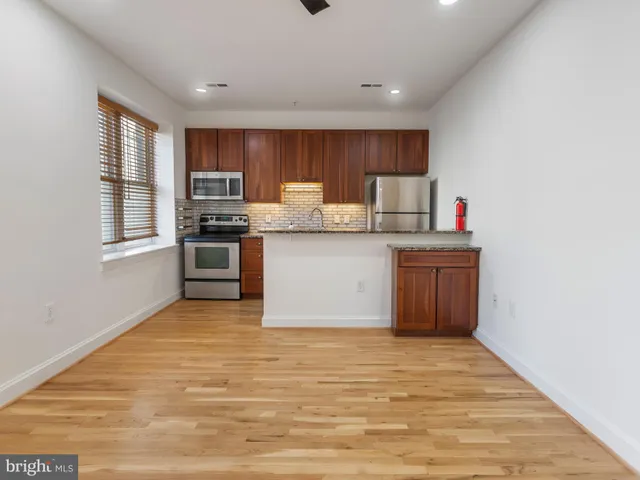 a kitchen with stainless steel appliances granite countertop a stove top oven sink and cabinets
