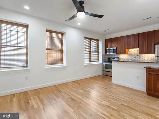 a kitchen with granite countertop wooden floors and white cabinets