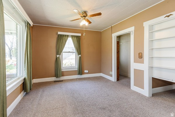365 West 200 North Logan, UT 84321 - Photo 7 of 45 Carpeted interior space featuring warm-toned walls, white trim, and a ceiling fan with light fixture