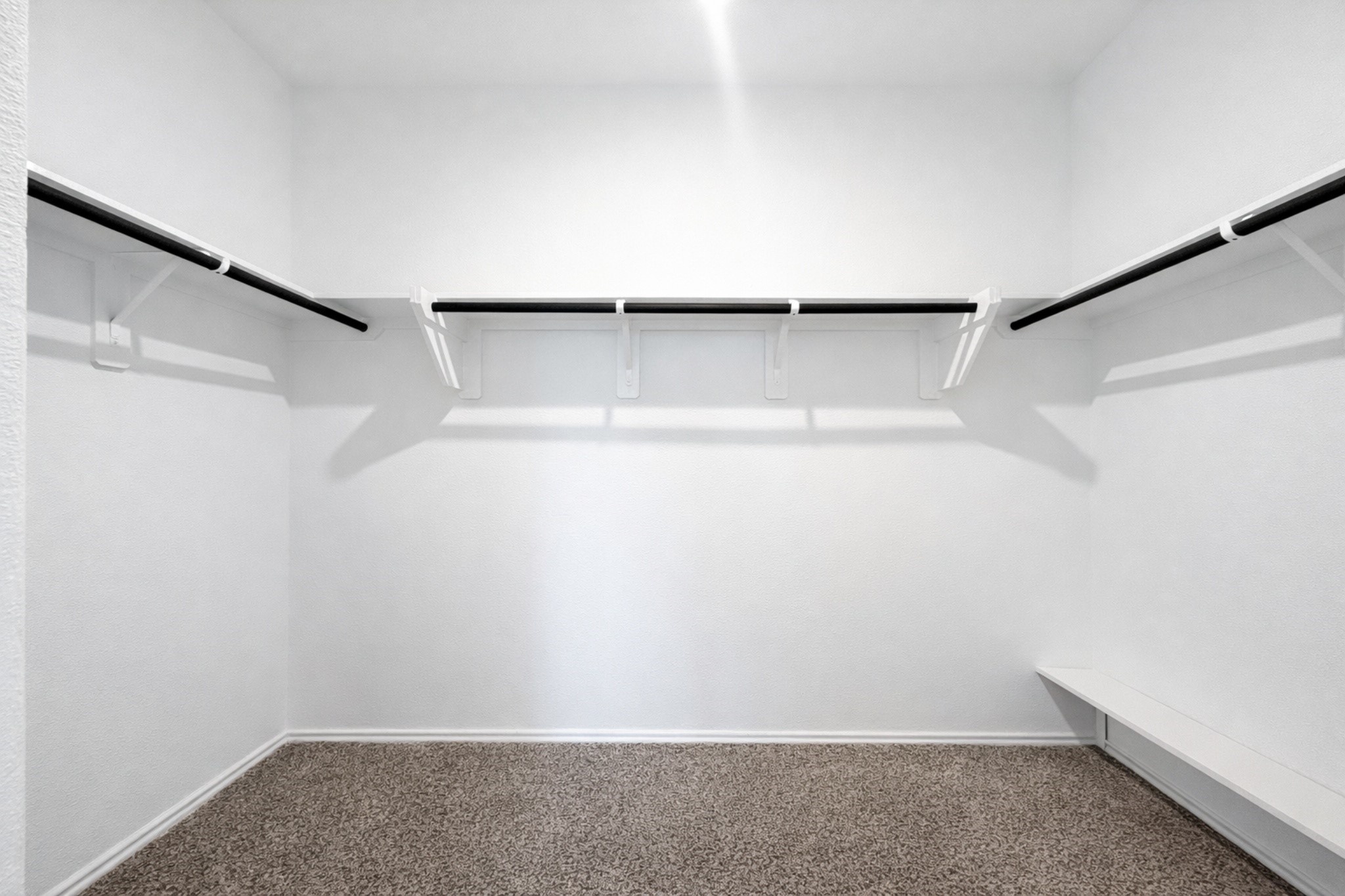 1739 Royal Rim Drive Houston, TX 77014 - Photo 11 of 20 Spacious walk-in closet featuring ample hanging rods and carpeted flooring, perfect for organizing your wardrobe.