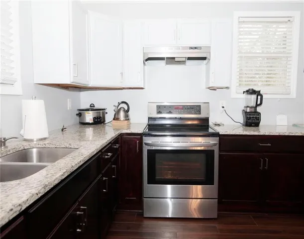 a kitchen with stainless steel appliances granite countertop a sink and a stove