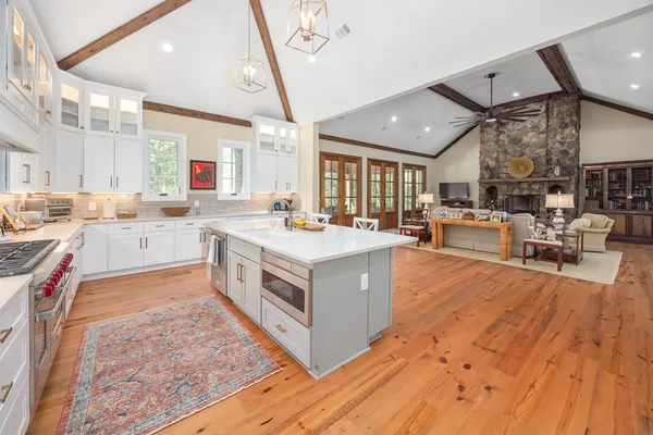 a kitchen with stainless steel appliances granite countertop a sink a stove and a wooden floors