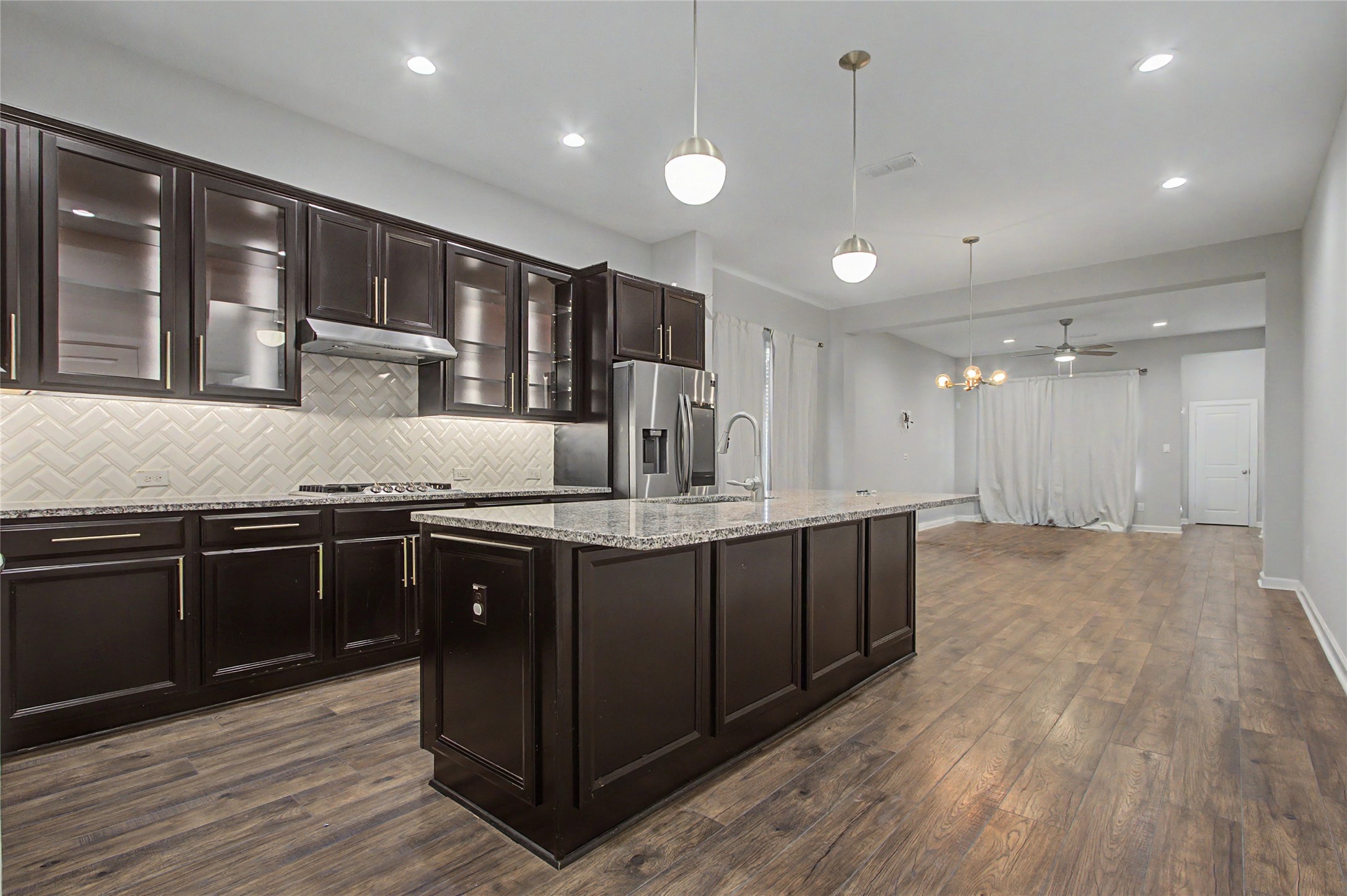 19718 Shinnery Ridge Court Cypress, TX 77433 - Photo 2 of 23 a kitchen with kitchen island granite countertop wooden cabinets and a granite counter tops