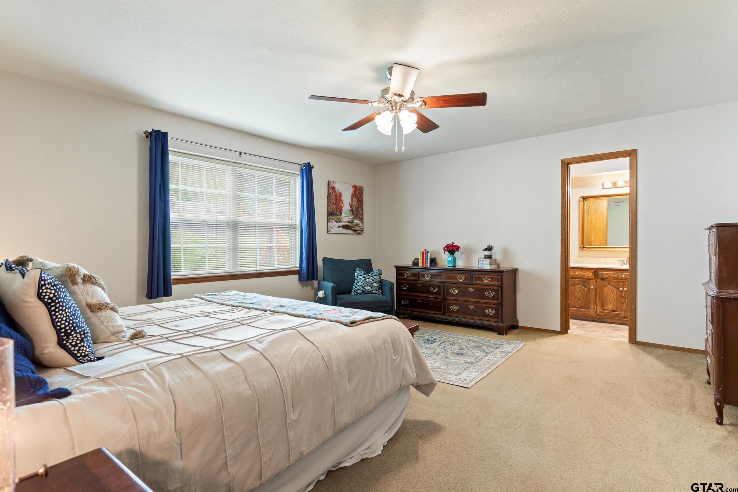 516 Ruthlynn Drive Longview, TX 75605 - Photo 17 of 34 a bedroom with a bed and a chandelier