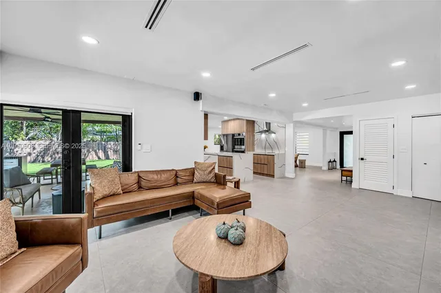 a kitchen that has a lot of white cabinets and stainless steel appliances