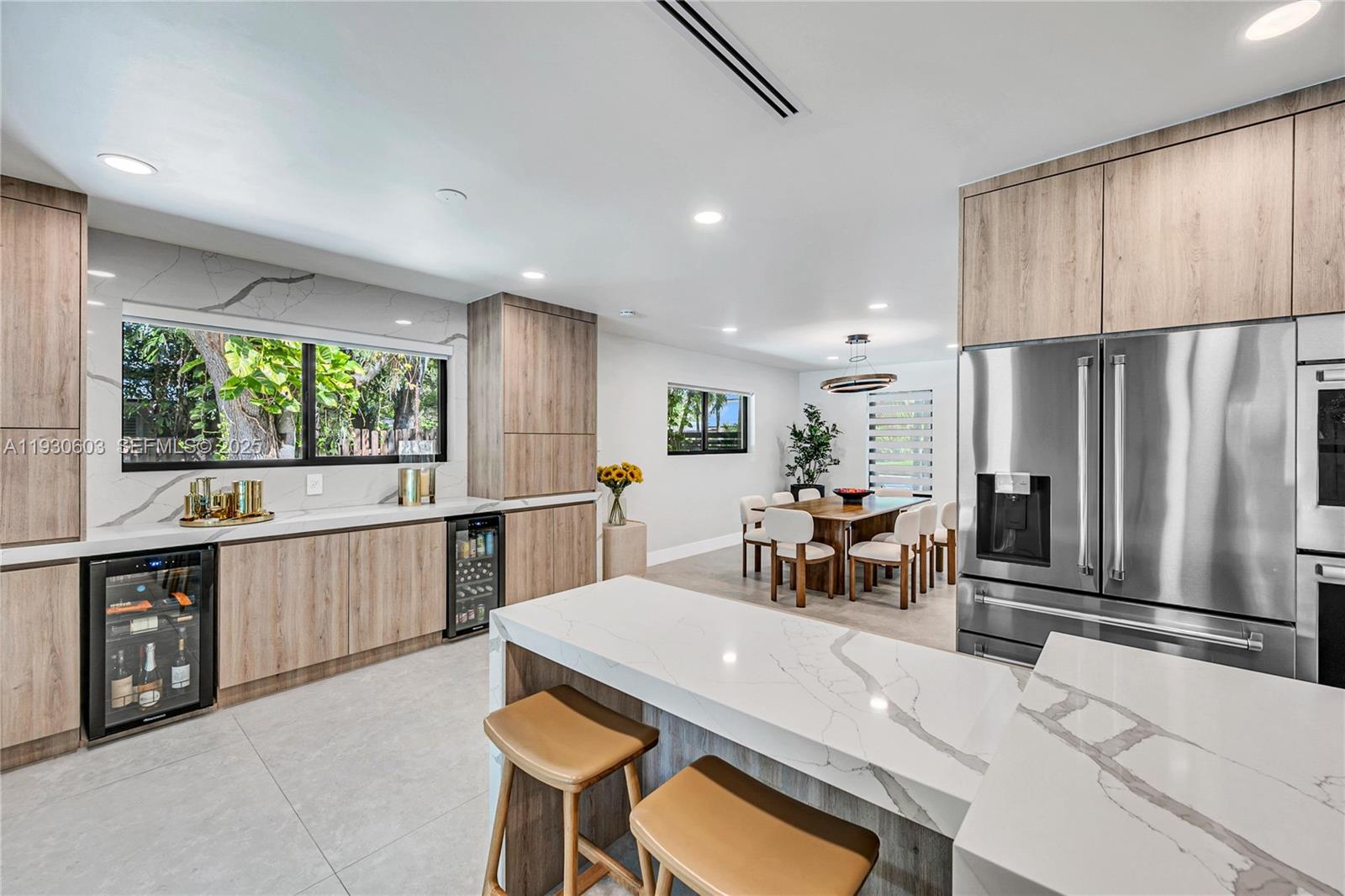 11340 Southwest 74th Court Pinecrest, FL 33156 - Photo 14 of 91 a kitchen with stainless steel appliances kitchen island granite countertop a table chairs and a refrigerator