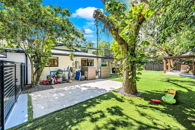 a view of a yard with plants and trees