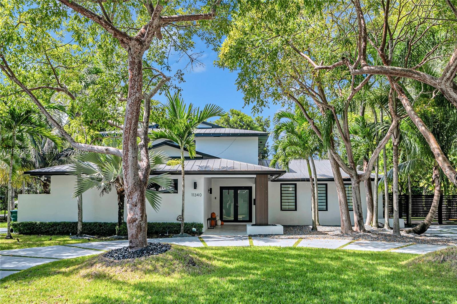 11340 Southwest 74th Court Pinecrest, FL 33156 - Photo 6 of 91 a front view of a house with garden