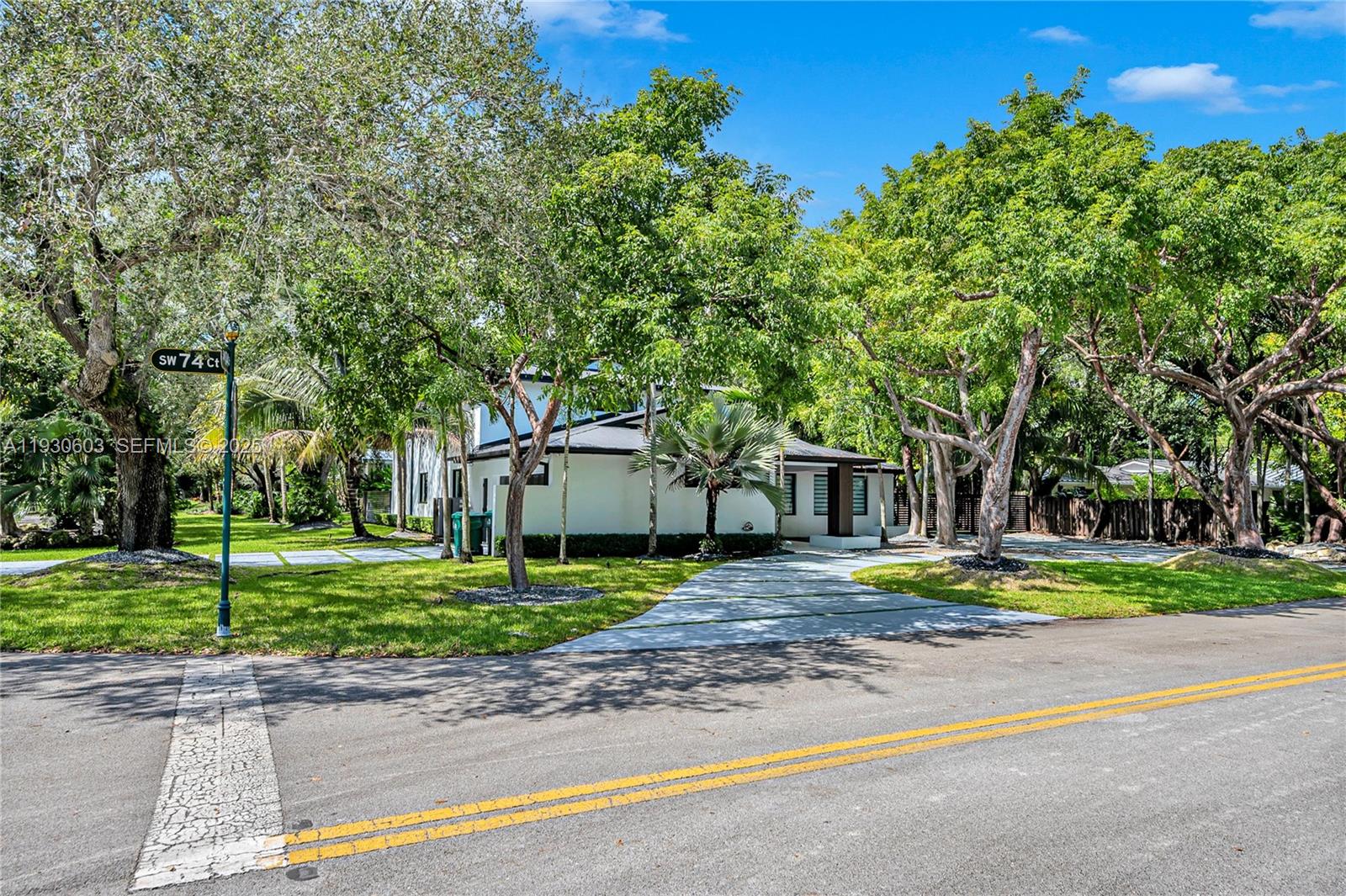 11340 Southwest 74th Court Pinecrest, FL 33156 - Photo 69 of 91 a front view of a house with a yard and trees