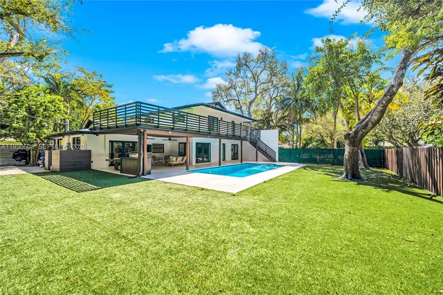 a view of a patio with table and chairs and couches with wooden fence