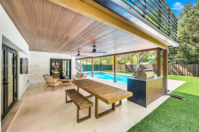 a kitchen with stainless steel appliances kitchen island granite countertop a table chairs and a refrigerator
