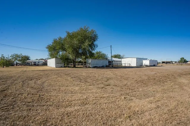 a view of dirt road with a building in the background
