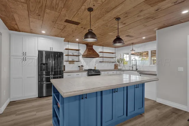 a kitchen with a stove a refrigerator and wooden floor