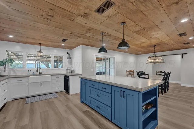 a kitchen with a sink cabinets and wooden floor