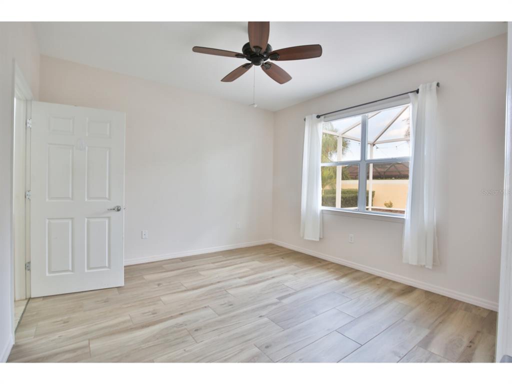 19108 Lappacio Street Venice, FL 34293 - Photo 12 of 33 a view of an empty room with wooden floor and a window
