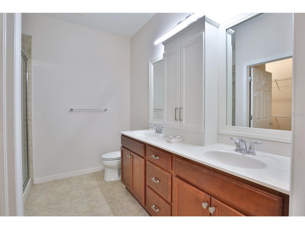 19108 Lappacio Street Venice, FL 34293 - Photo 15 of 33 a bathroom with a double vanity sink a toilet and a mirror