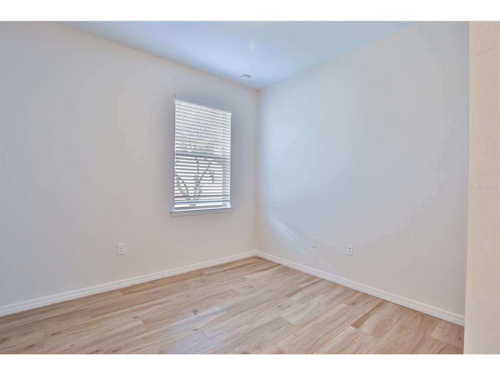19108 Lappacio Street Venice, FL 34293 - Photo 20 of 33 a view of an empty room with wooden floor and a window