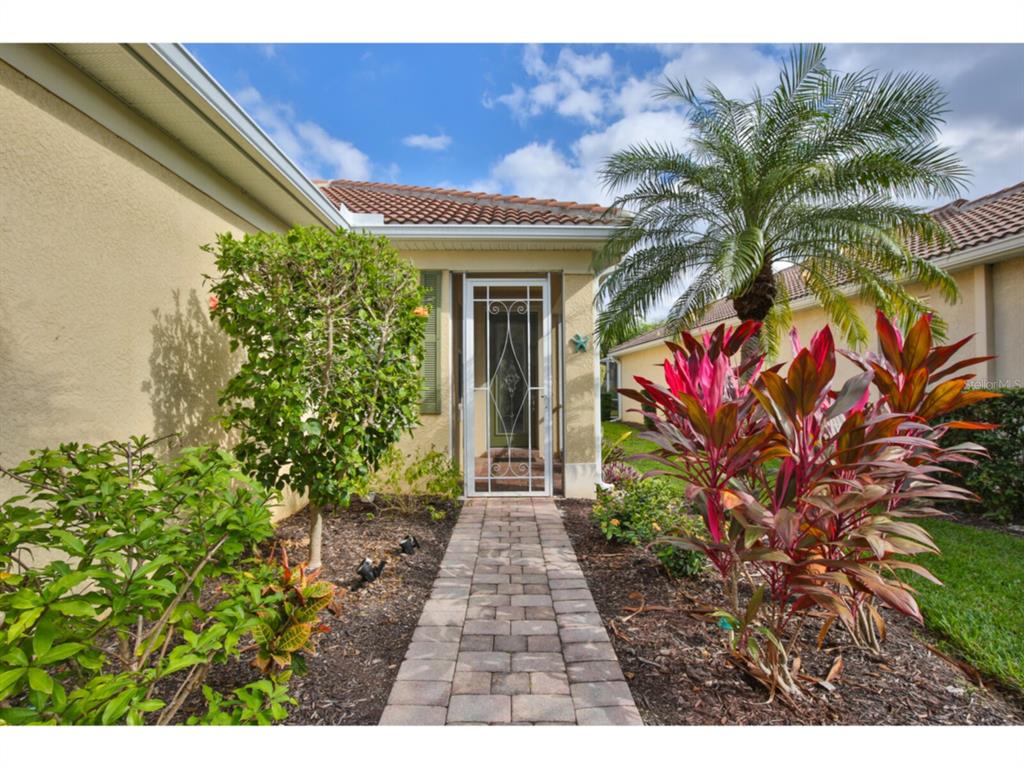 19108 Lappacio Street Venice, FL 34293 - Photo 2 of 33 a view of a pathway with a flower garden
