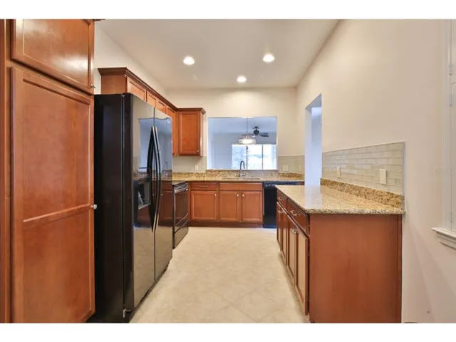a kitchen with stainless steel appliances a refrigerator and a wooden floor