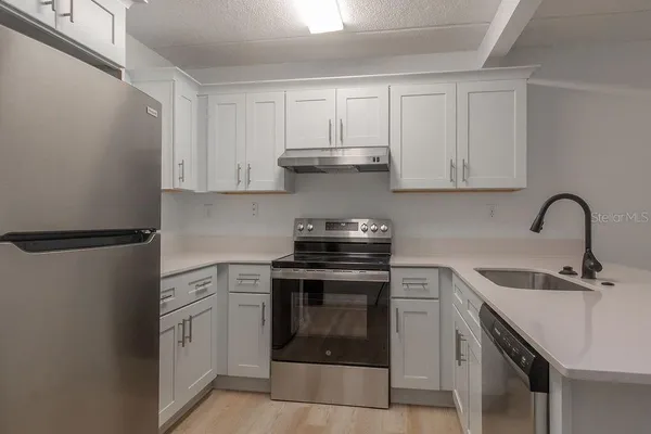 a kitchen with white cabinets and stainless steel appliances