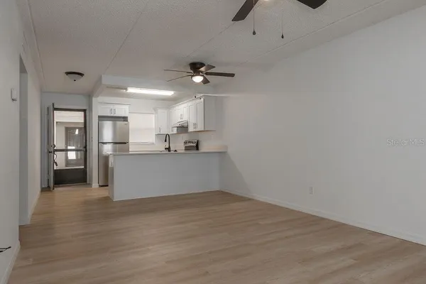 a view of a kitchen with wooden floor and a kitchen space